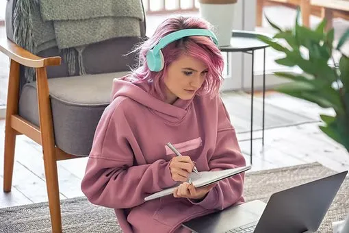 Teenager wearing headphones while studying