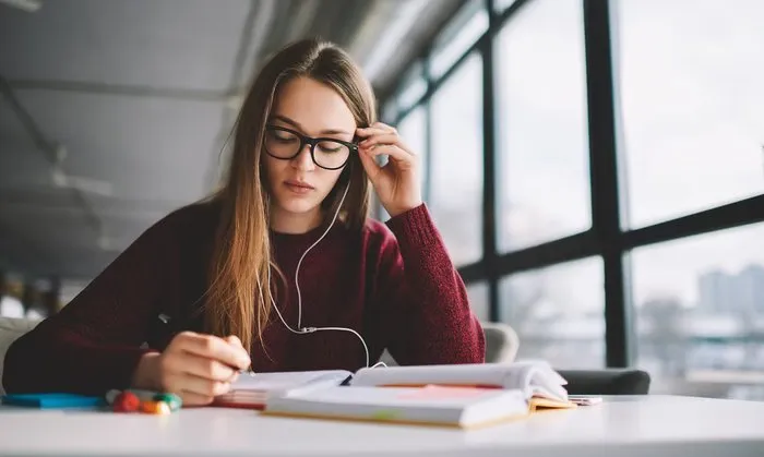 Young woman focused on studying, wearing glasses