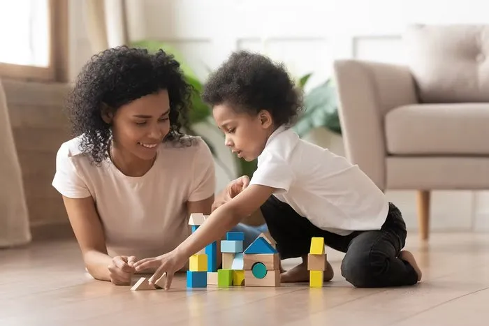 Mãe brincando com criança usando blocos de montar